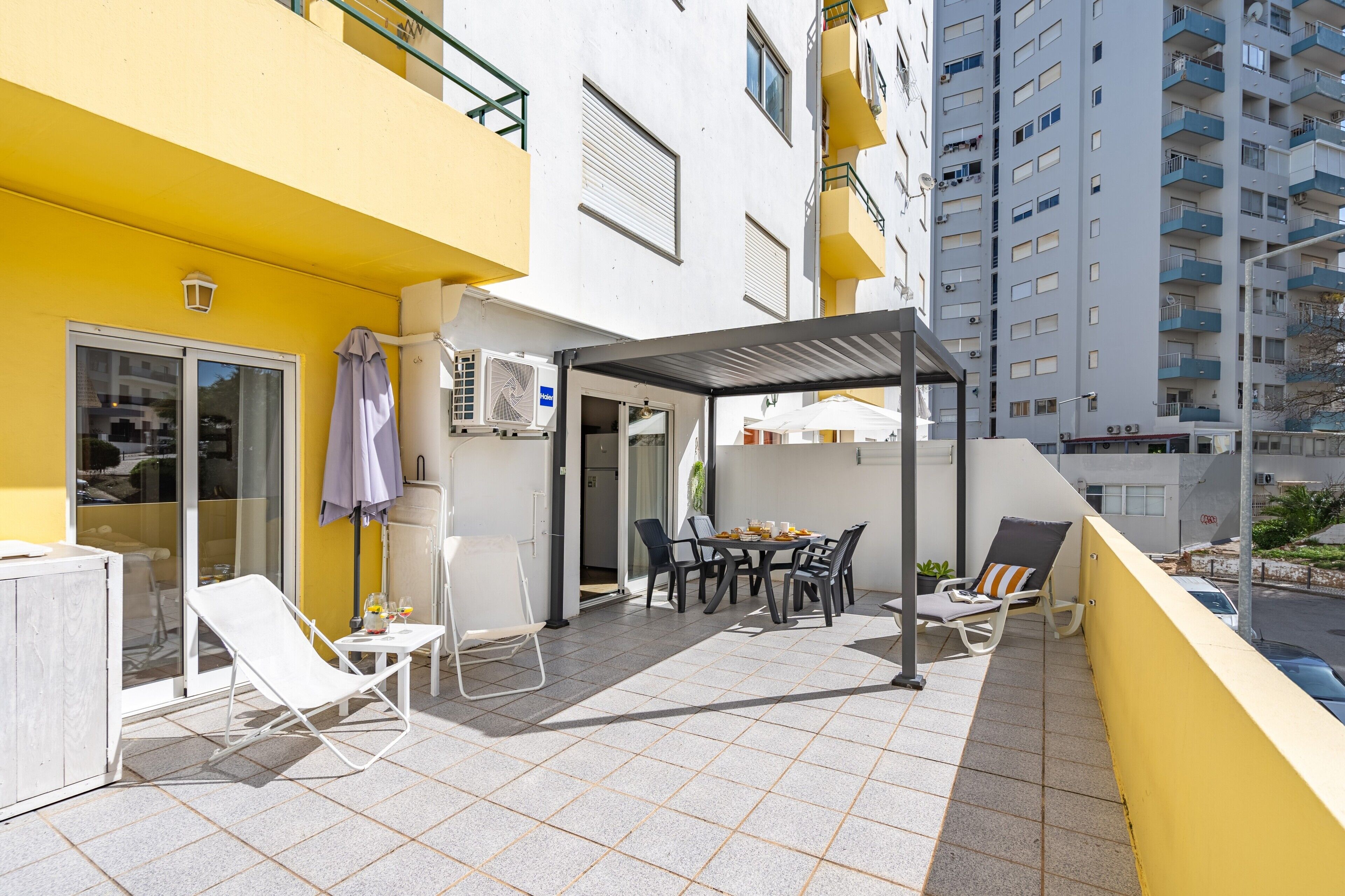 Un balcon avec une table, des chaises et un espace abrité.