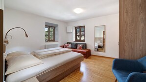 A bedroom with a bed, a bedside lamp, a window, a radiator, a mirror, and a wardrobe. - Holiday Apartment 'Wielander B West' with Mountain View, Shared Garden and Wi-Fi (Laces)