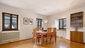 A dining area with a table, chairs, a radiator, and a shelf with glassware. - Holiday Apartment 'Wielander B West' with Mountain View, Shared Garden and Wi-Fi (Laces)