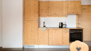 A kitchen with wooden cabinets, a coffee maker, and a dishwasher.