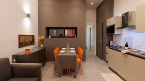 Une cuisine moderne avec un coin repas, comprenant une table avec des chaises, un canapé et un tableau au mur.