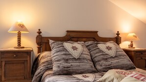 A bed with heart-shaped pillows, wooden headboard, and bedside lamps. - La Sabaudia Gîte in the Vosges – Up to 10 Guests (Gérardmer)