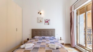 Ein Schlafzimmer mit Bett, Nachttisch, Kleiderschrank und einem Fenster mit Blick.