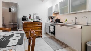 Une cuisine de taille réduite équipée d’un réfrigérateur, d’une cuisinière, d’un four à micro-ondes et de placards.