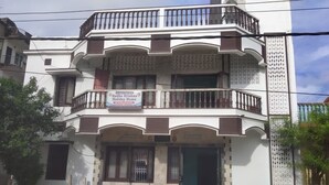 A multi-story building with a sign advertising 'Radha Krishna Holiday Home'. - Puri (Puri)
