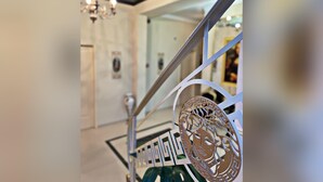 A modern interior with a metal staircase, a chandelier, and a patterned wall. - Hotel Diamond (Chisinau)