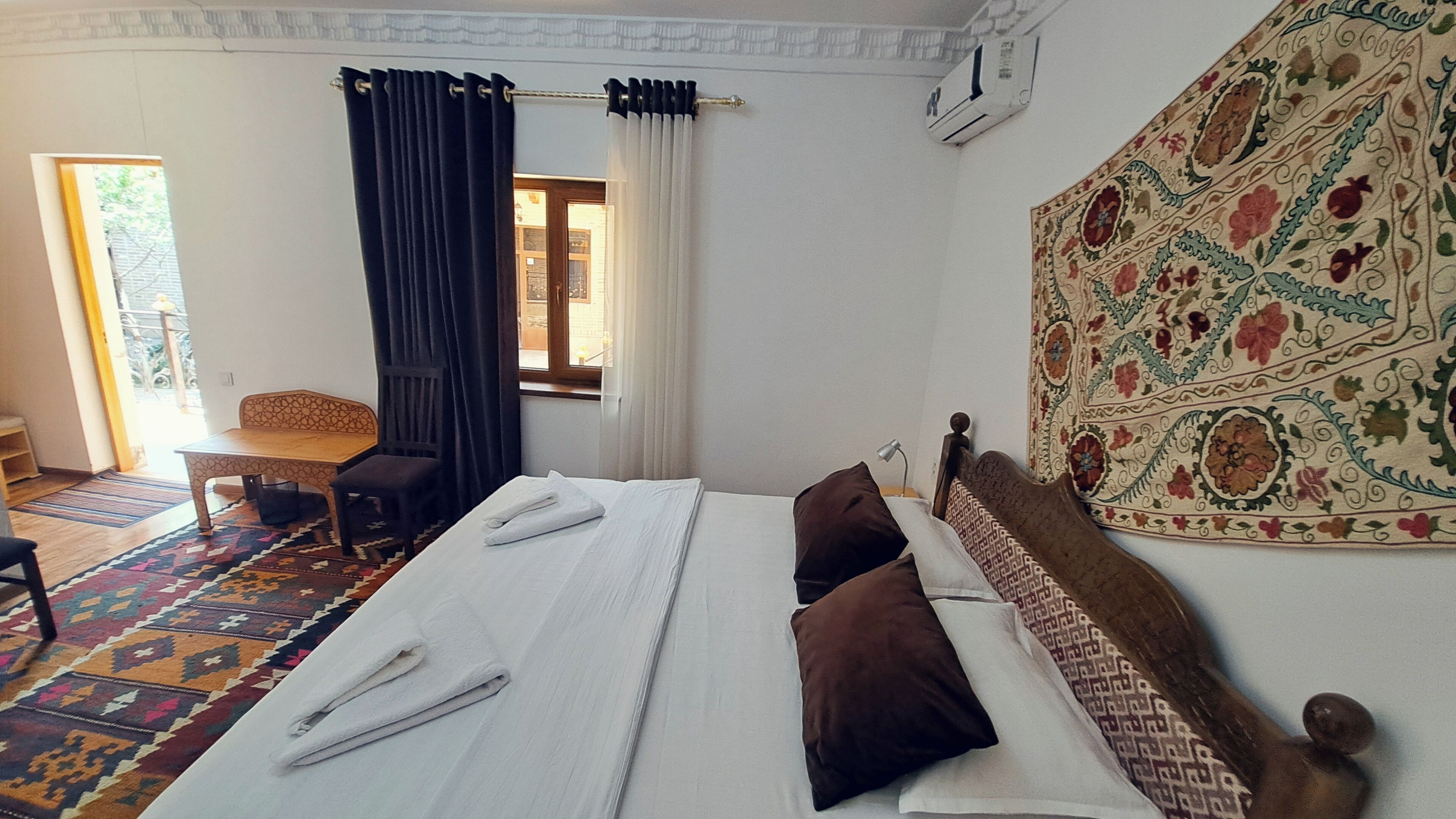 Une pièce comprenant un lit, une chaise, une table et une décoration murale à motifs.
