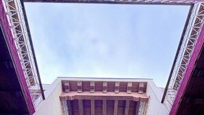 A building with a symmetrical facade, a central arched window, and a chandelier. - Hotel Ansi Boutique W&S terrace (Bukhara)