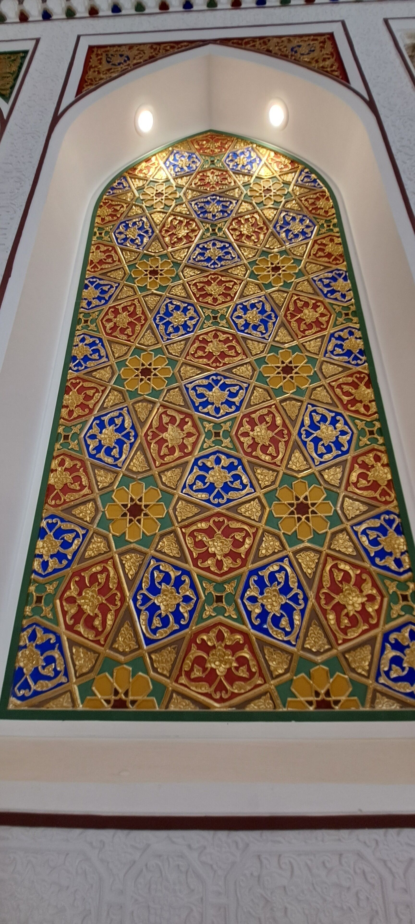 Un mur orné d’un motif géométrique complexe, avec une structure en forme de dôme au centre.
