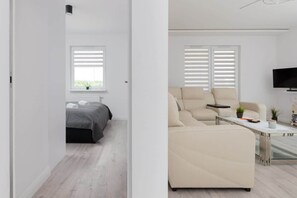 A modern living room with a sofa, a coffee table, and a television.