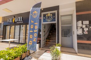 A hotel entrance with a staircase, a banner, and a Kill Grill restaurant sign. - Hotel Beler (Vlorë)