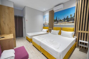 A hotel room with two beds, a wooden wardrobe, a desk, and a bathroom with a shower curtain. - Hotel Beler (Vlorë)