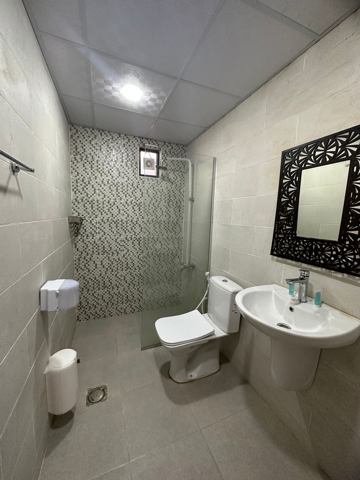 A bathroom with a toilet, bidet, sink, and shower.