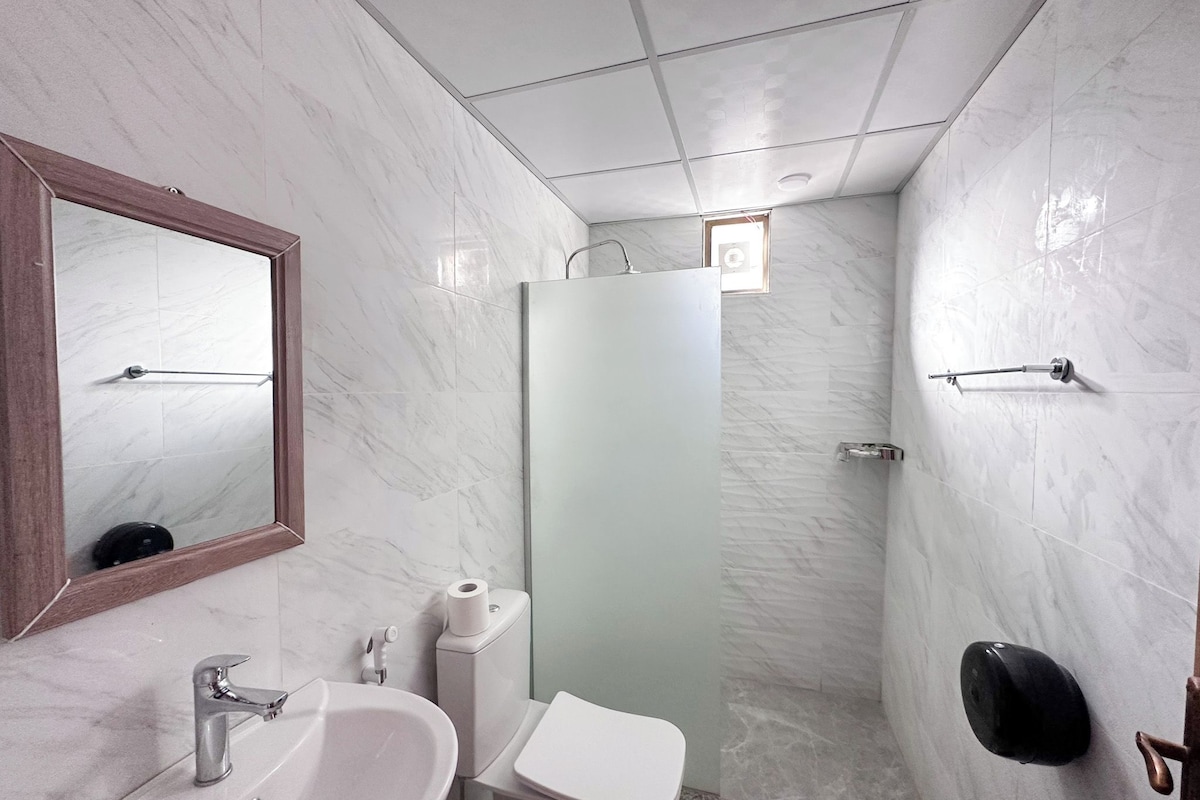 A bathroom with a sink, toilet, and shower.