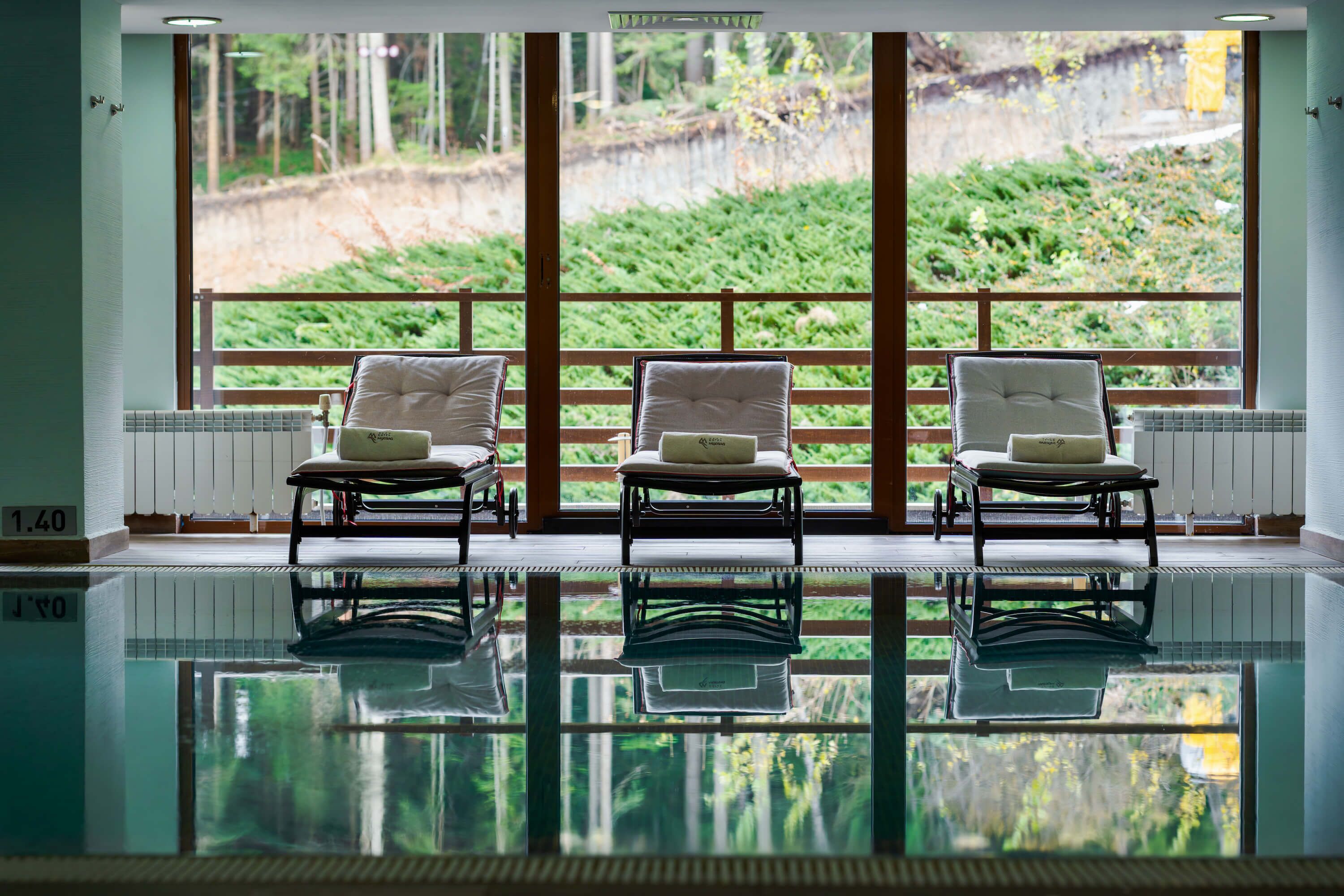 Una piscina cubierta, sombrillas, tumbonas