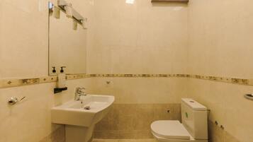 A bathroom with a sink, toilet, and a mirror.