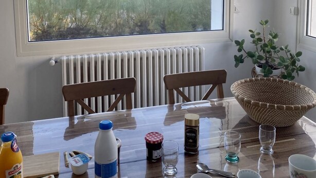 A dining area with a view of the beach, a table set with various items, and hanging light fixtures. -  The house right on the water with direct access to the beach. (Ouistreham)