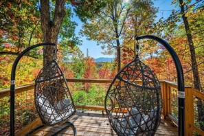 A wooden deck with two wicker chairs overlooking a forest with autumn foliage. - Secluded cabin w views! Game Room & FREE TIX! (Sevierville)