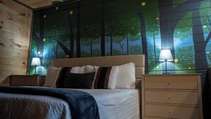 A bedroom with a bed, two bedside tables, and a wall mural. - Secluded cabin w views! Game Room & FREE TIX! (Sevierville)