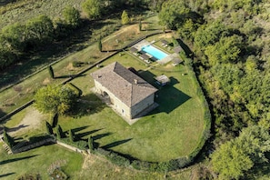 A stone building with a tiled roof, surrounded by a well-maintained lawn and a swimming pool. - Wonderful private villa with A/C, internet, private pool, patio, pets allowed and panoramic view (Badia Agnano)