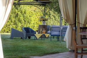 A garden area with outdoor seating, including chairs and a table, and a pergola structure. - Wonderful private villa with A/C, internet, private pool, patio, pets allowed and panoramic view (Badia Agnano)