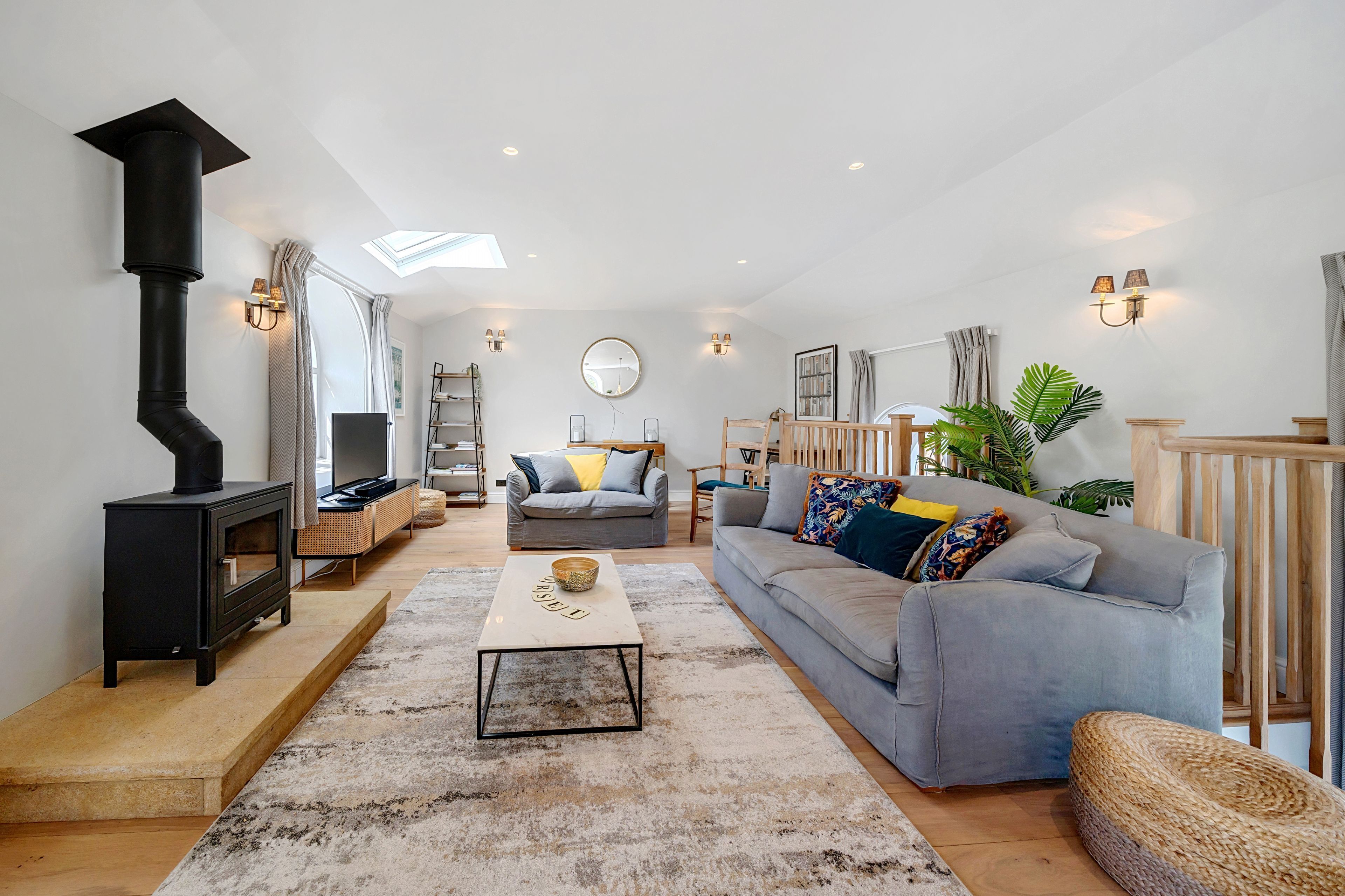 A living room with a fireplace, sofa, coffee table, and a staircase leading to an upper level.