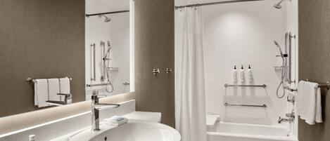 Une salle de bain moderne avec un grand lavabo, une baignoire et un espace douche.
