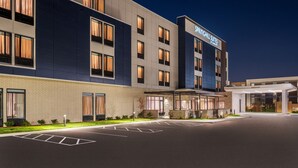 Un hotel moderno con un amplio estacionamiento, una entrada cubierta y un letrero que dice "Springhill Suites by Wyndham".