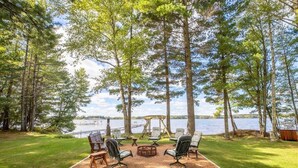 A lakeside patio with outdoor seating and a swing set. - Round Lake Retreat for All Seasons (Park Falls)