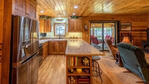 A wooden cabin interior with a kitchen, dining area, and a cozy living space. - Round Lake Retreat for All Seasons (Park Falls)