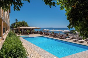 Una piscina al aire libre de temporada, sombrillas