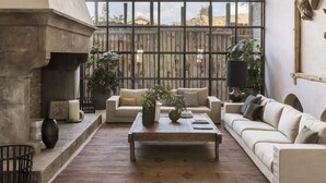 Un amplio salón con un ventanal grande, una chimenea y un conjunto de asientos acogedor.