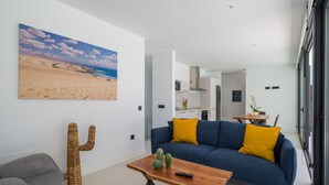 Una sala de estar moderna con un sofá azul, una mesa de centro de madera y una decoración de cactus.