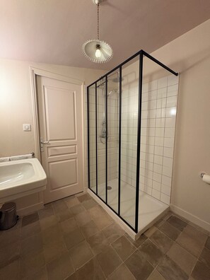 Ein Badezimmer mit Duschkabine, Waschbecken und Toilette.