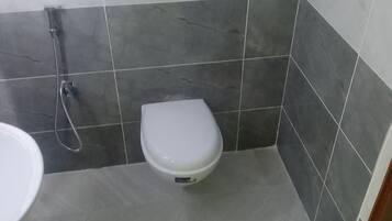 Un baño pequeño con inodoro, ducha y lavabo.