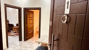 Ein Hotel Eingang mit Marmorboden, einer hölzernen Bank und einer Tür mit der Nummer 1.