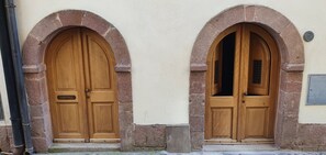 Two wooden doors with arched tops, set in a building with a textured wall. - Single-family home with a large furnished patio; pets allowed (Bosa)
