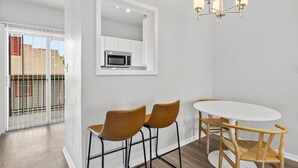 A dining area with a white table and two brown chairs, a white-framed mirror, and a chandelier. - Cozy BoHo 2bd Apartment | Cedar Park/North Austin (Austin)