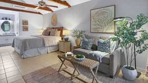 A well-lit living room with a bed, a sofa, a coffee table, and a potted plant. - Lily Pad I Wimberley cottage on Cypress Creek! (Wimberley)