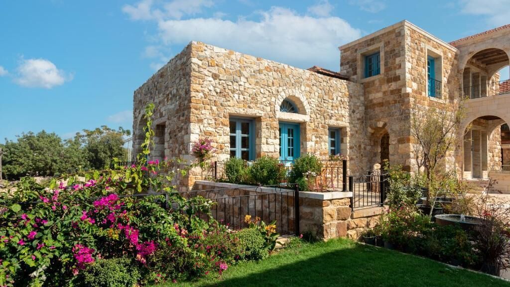 A stone building with a garden in front.