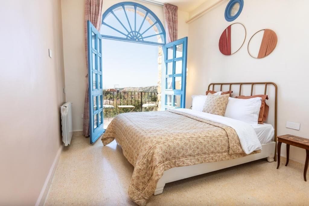Un dormitorio con cama, ventana con vistas y radiador.