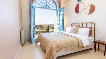 Un dormitorio con cama, ventana con vistas y radiador.