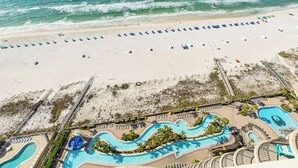Un resort con playa, zona de piscina y una torre de socorristas.
