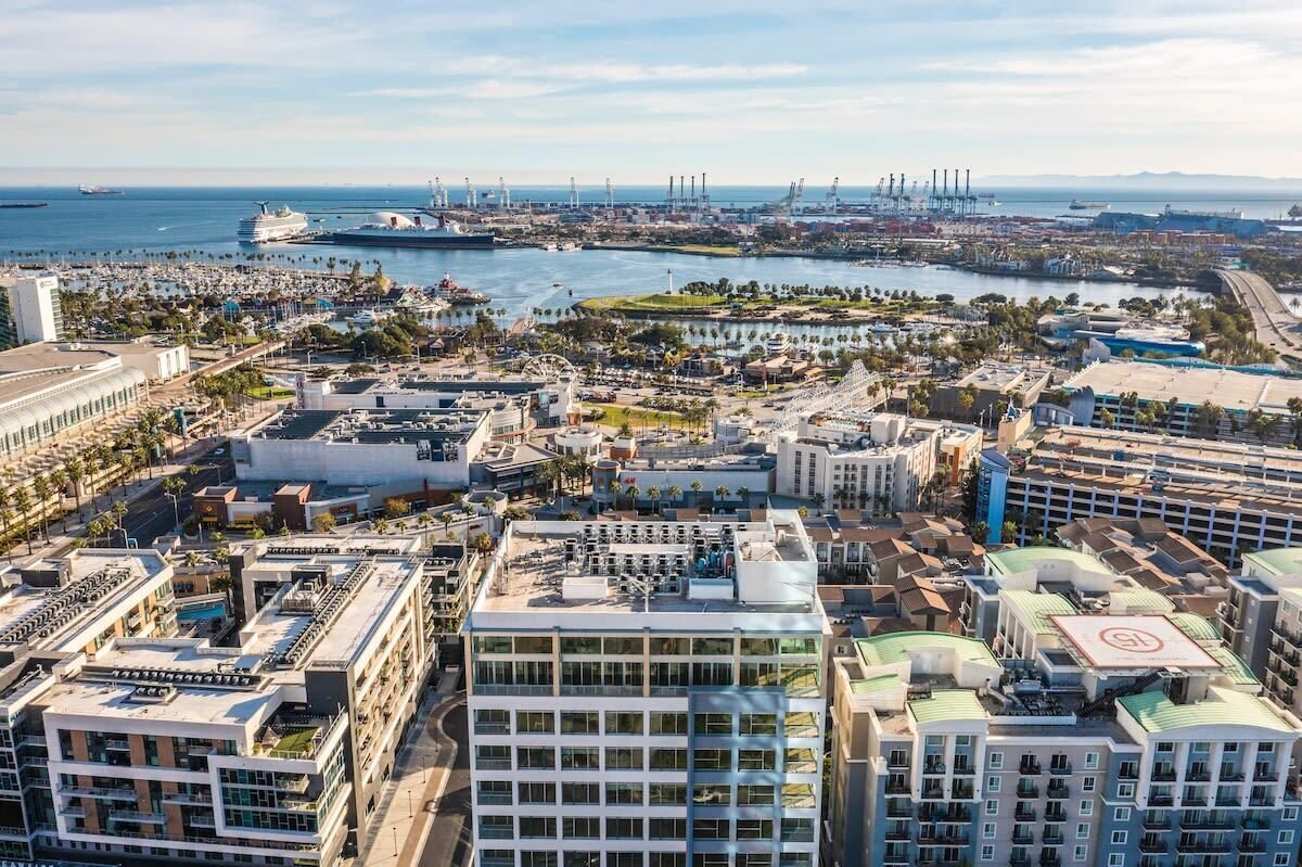 A high-rise building with multiple floors, a prominent glass facade, and a rooftop terrace.