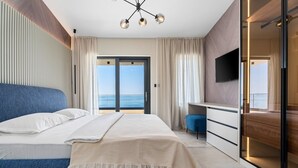 A modern bedroom with a large bed, a desk, and a TV. - Stylish property with heated 32sqm private pool, 5 bedrooms, 5 bathrooms, 1km from the beach (Podstrana)