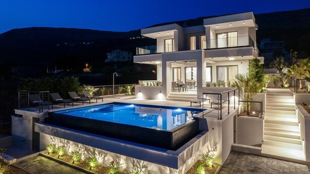 A modern two-story house with a swimming pool, outdoor seating, and a staircase leading to the upper level. - Stylish property with heated 32sqm private pool, 5 bedrooms, 5 bathrooms, 1km from the beach (Podstrana)