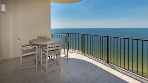 Enjoy breathtaking sea views from this balcony with a round table and four chairs.