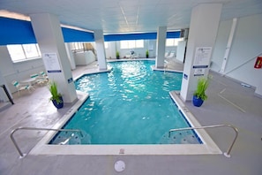 An indoor swimming pool with clear water, surrounded by white pillars, and a blue ceiling. - Marigot Beach 705 1 Bedroom Condo by RedAwning (Ocean City)