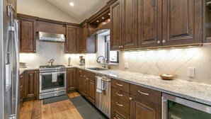 Une cuisine moderne avec des meubles en bois, des appareils en acier inoxydable et un plan de travail en marbre.