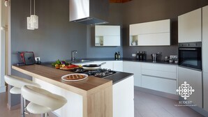 Una cocina moderna con una isla central, electrodomésticos de acero inoxidable y un diseño minimalista.
